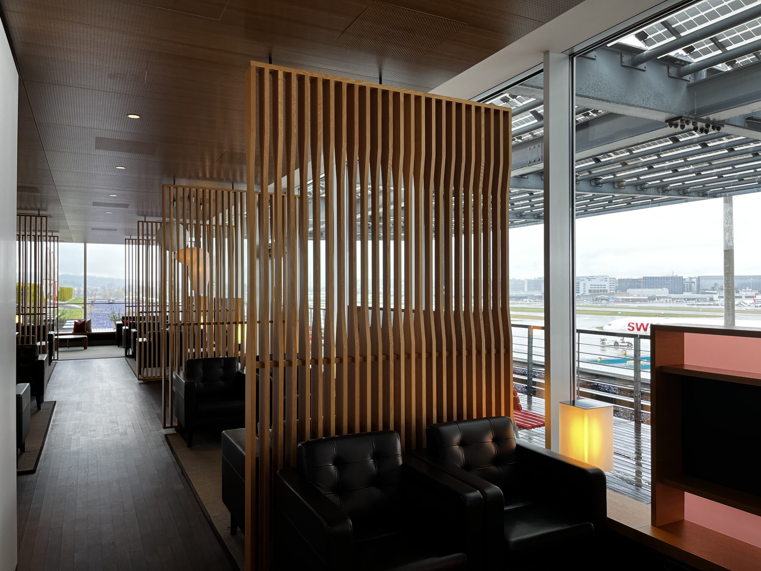 Swiss First Class Lounge — window seating overlooking the E-apron